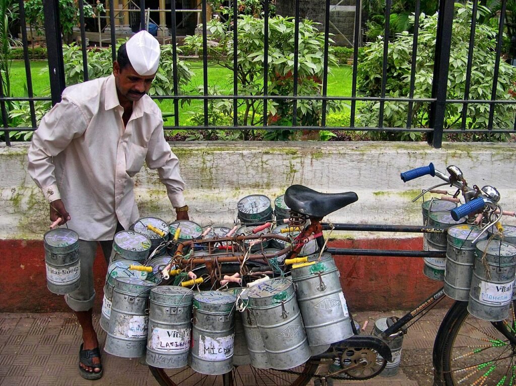 Mumbai dabbawala carrying steel lunchboxes.