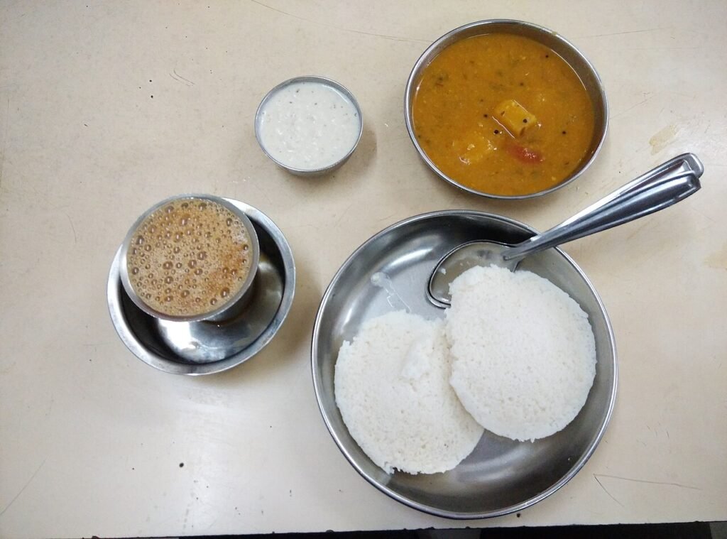 Idli sambar and South Indian filter coffee served at a table.
